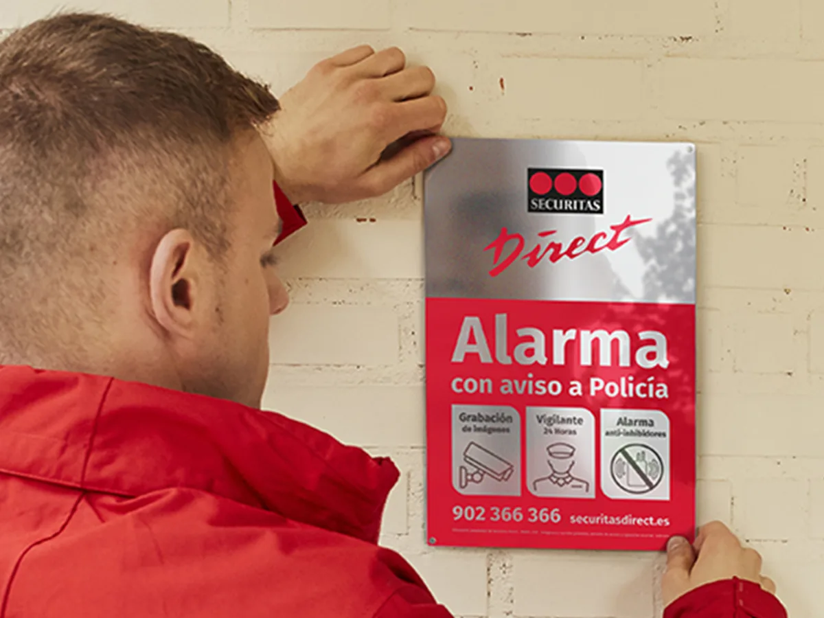Instalador colocando placa disuasoria de Verisure (antes Securitas Direct)